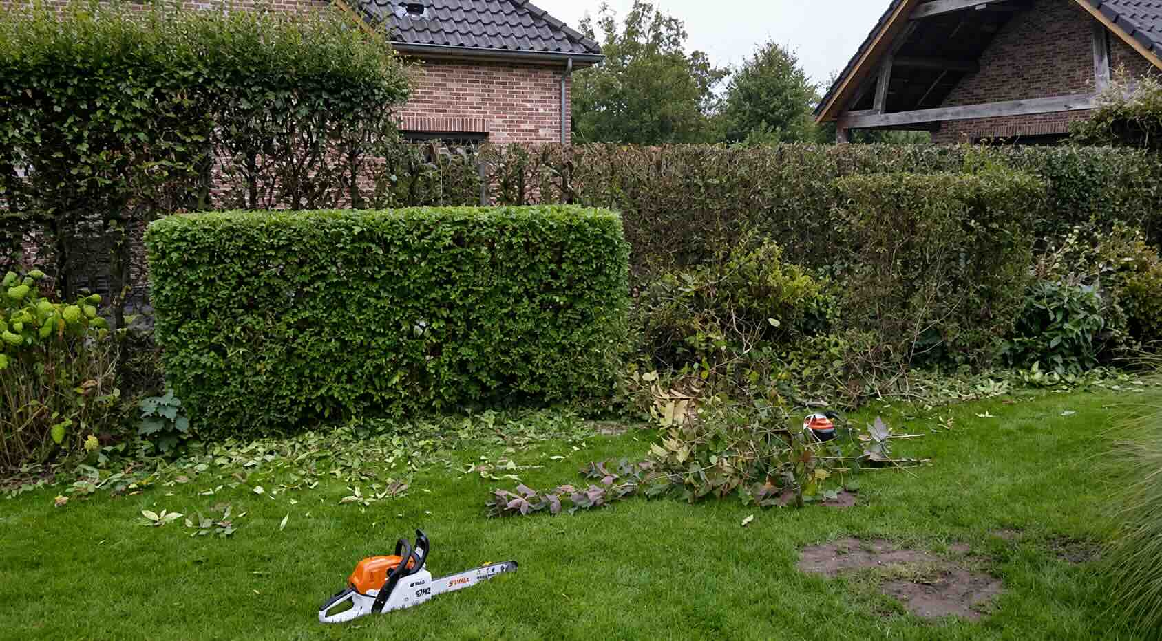 Geschoren haag en opgeruimd snoeiafval in een onderhouden tuin